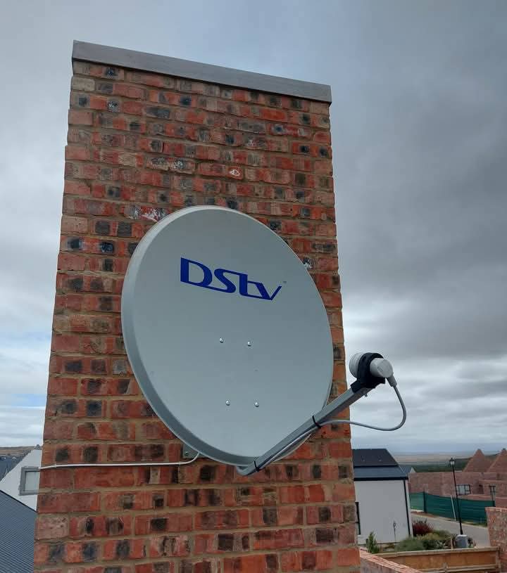 DStv technician installing dish on Durban rooftop